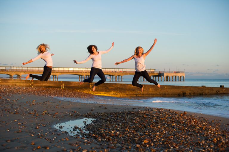Dorset Portrait Photographer Bournemouth beach 3 girls jumping with sea