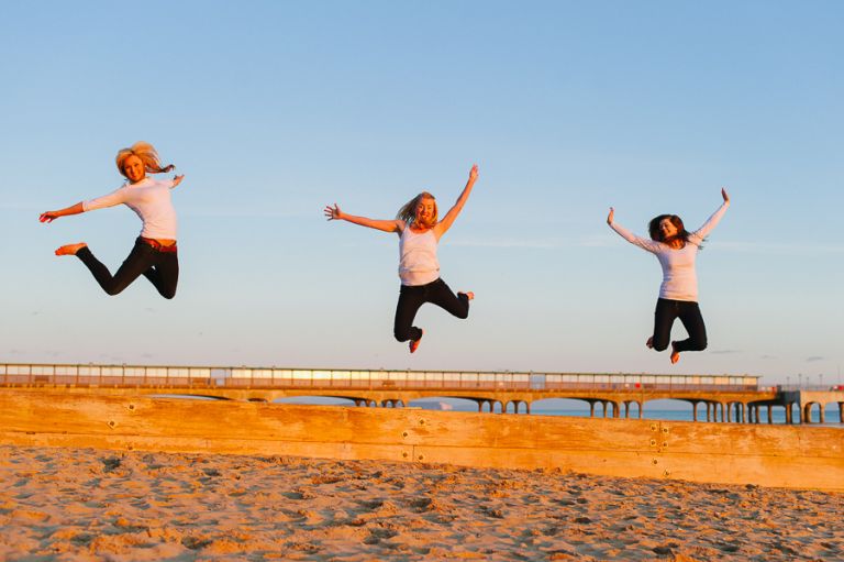Dorset Portrait Photographer Bournemouth beach 3 girls jumping