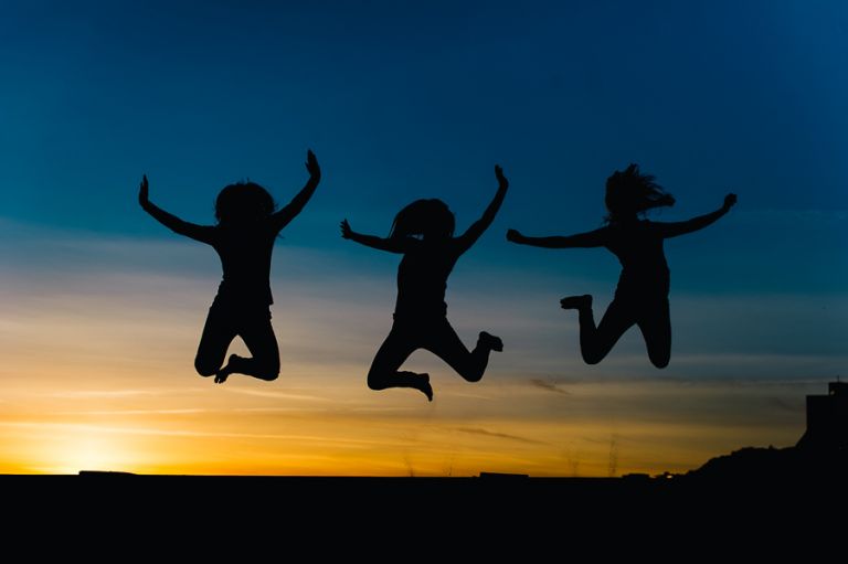 Dorset Portrait Photographer Bournemouth beach 3 girls jumping in silhoutte